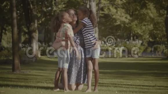 两个可爱的女儿在大自然中亲吻母亲视频的预览图