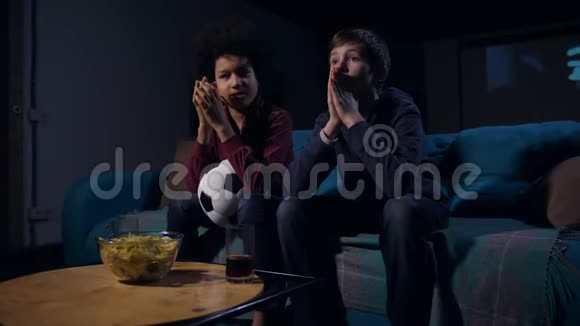 足球迷青少年在电视上观看比赛视频的预览图