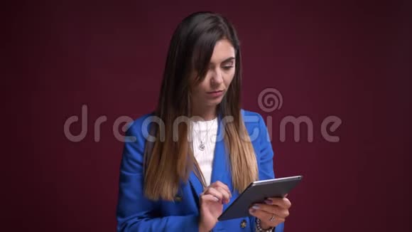 在镜头前用平板电脑拍摄的有魅力的白种人女性的特写视频的预览图