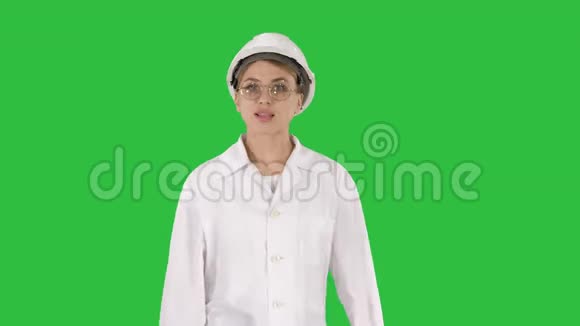 戴着安全帽和实验室外套的成熟女工程师在绿色屏幕上讲话和展示一些东西视频的预览图