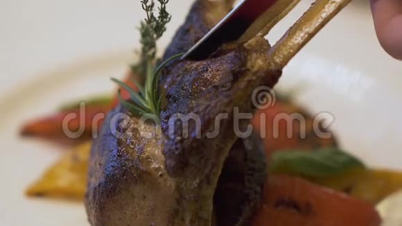 在豪华餐厅顾客用刀子切下新鲜美味的肋骨多汁的烤排骨视频的预览图