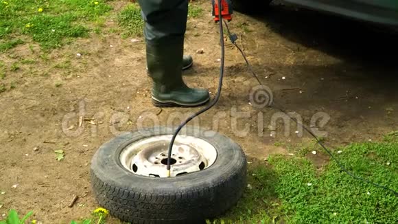 一个人用压缩机充气一个旧汽车车轮视频的预览图