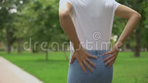 女人在公园散步时感到背痛肾脏发炎关节炎视频的预览图