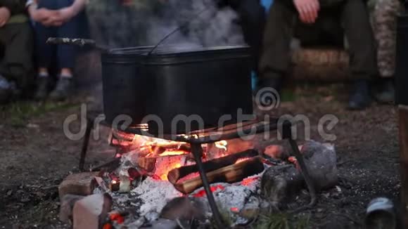人们用篝火在金属桶里加热水等待它加热视频的预览图