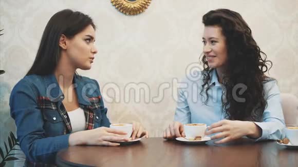 三个年轻女孩坐在咖啡店里聊天在此期间享用卡布奇诺很高兴和你在一起视频的预览图