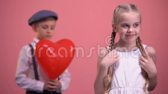 可爱害羞的女孩微笑着带着心形气球的男孩准备给她惊喜视频的预览图
