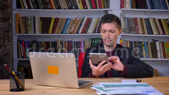 颇具吸引力的是一名男性学生坐在笔记本电脑前的平板电脑上脸上带着担忧的表情视频的预览图