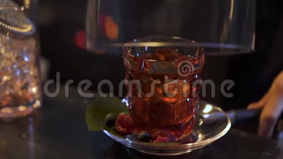 酒保在酒吧里准备不寻常的鸡尾酒酒保在大碗下用酒精覆盖玻璃视频的预览图