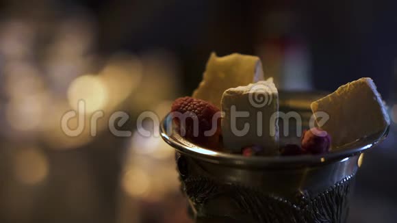 在一家餐馆提供的一个昂贵的优雅玻璃中从冰淇淋覆盆子努盖特和其他浆果中提取甜点关闭视频的预览图
