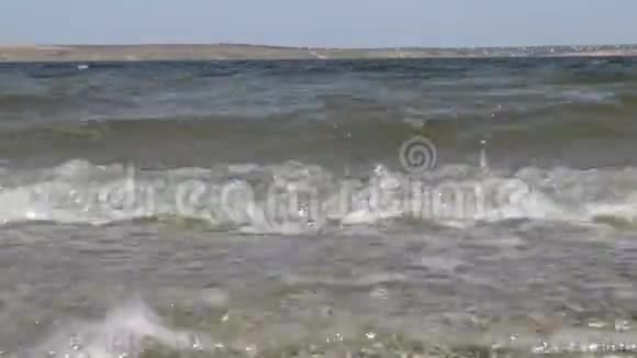 带有微藻波的脏水正向乌克兰提利古尔河口的沙质唾沫上的镜头移动视频的预览图