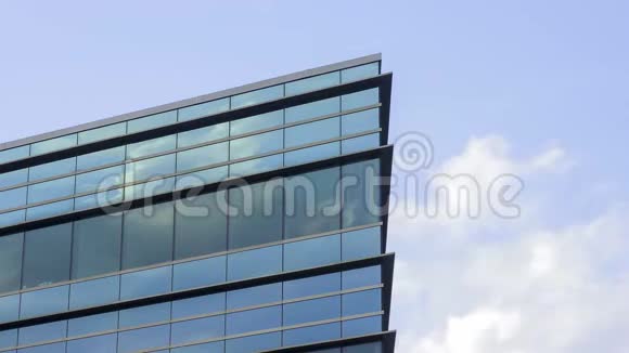 市中心的一个玻璃办公楼角落反映了下午4KUHD时代的戏剧性云彩视频的预览图