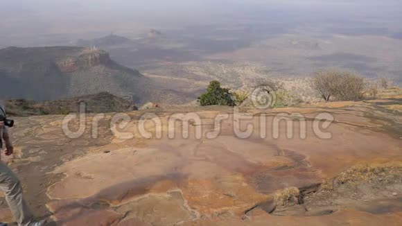 旅游摄影师在美丽的山谷景色的火山顶部漫步视频的预览图