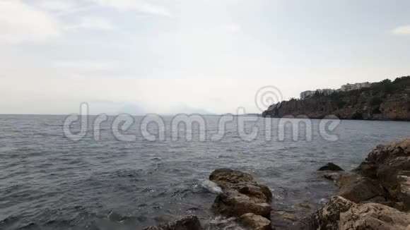 海浪拍打在岩石海岸的岩石附近视频的预览图