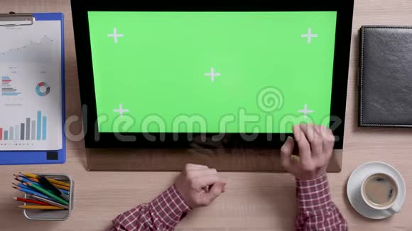 一个男人的手触摸触摸屏上绿色屏幕的右下角视频的预览图