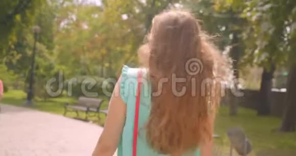 特写后景照片年轻可爱的女性走着转过身来看着镜头露出一头讨人喜欢的微笑视频的预览图