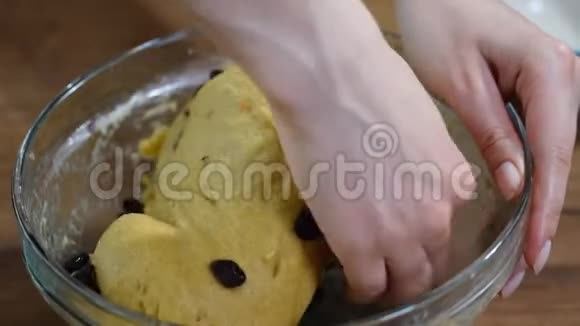 烘焙概念女人把面团揉在碗里用葡萄干做甜面包视频的预览图