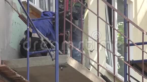阳台和原木框架的专业焊接工人在施工现场工作视频的预览图