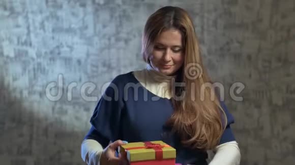 一个可爱的女孩比较了两件礼物然后打开其中一件视频的预览图
