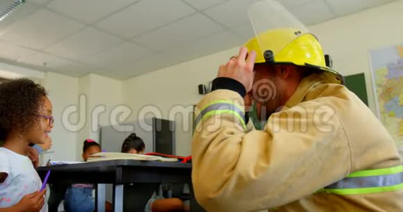 年轻的白种人男性消防员在4k教室教女学生消防安全视频的预览图