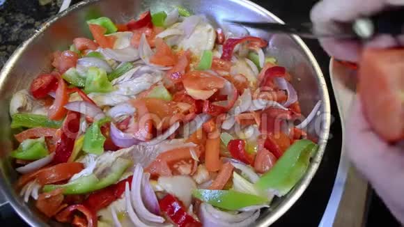 女人用鸡肉和其他蔬菜把新鲜的番茄切成砂锅视频的预览图