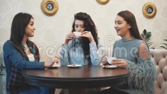 三个年轻女孩坐在咖啡店里聊天在此期间享用卡布奇诺很高兴和你在一起视频的预览图