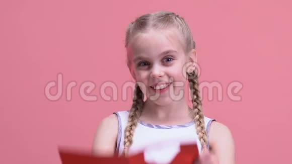 在情人节卡片上看着心的漂亮女孩在节日里玩得很开心视频的预览图