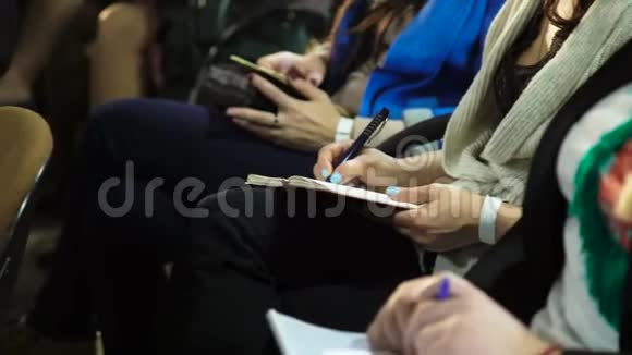 妇女在商务会议上坐着在笔记本上做笔记视频的预览图