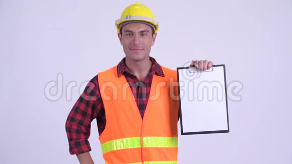 年轻快乐的西班牙裔建筑工人展示剪贴板竖起大拇指视频的预览图