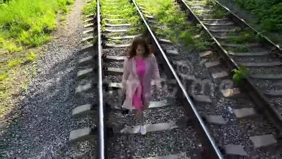 一个走在铁轨上的年轻女孩在公园里远足视频的预览图