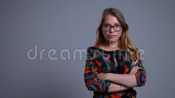戴眼镜的年轻自信的白种人女性的特写照片双臂交叉在胸前看着镜头视频的预览图