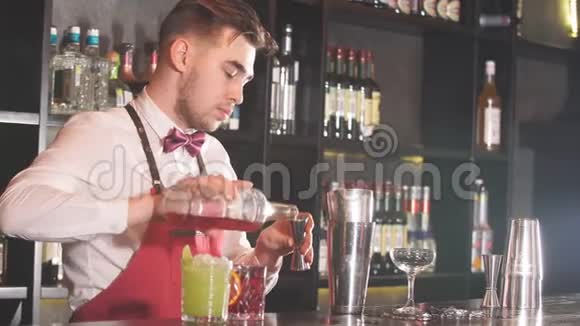 酒吧服务员穿着领结白色衬衫和红色围裙在餐厅的酒吧柜台做鸡尾酒视频的预览图