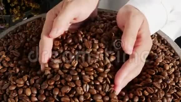 把咖啡豆倒入一堆咖啡豆的手合起来视频的预览图