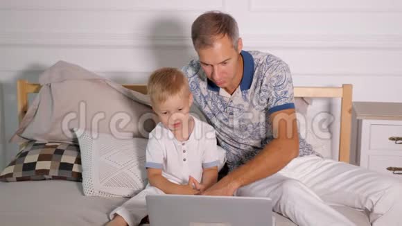 有儿子在床上看手提电脑的男人视频的预览图