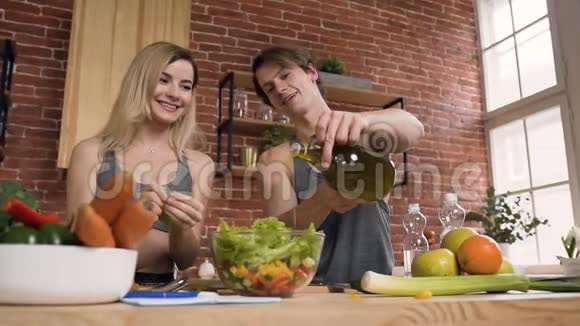 英俊的运动男人和女人一起在厨房做饭视频的预览图