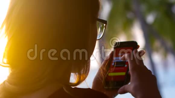 智能手机上戴眼镜上网的近边女孩视频的预览图