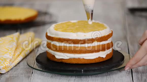 面包师用奶油准备蛋糕用鲜奶油把面包师的光滑蛋糕合上视频的预览图