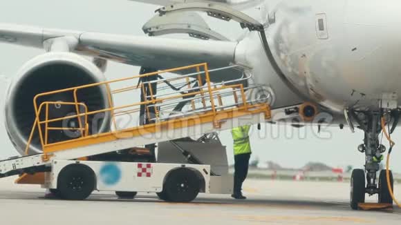 一名男工将一部可运输的自动扶梯连接到飞机上视频的预览图
