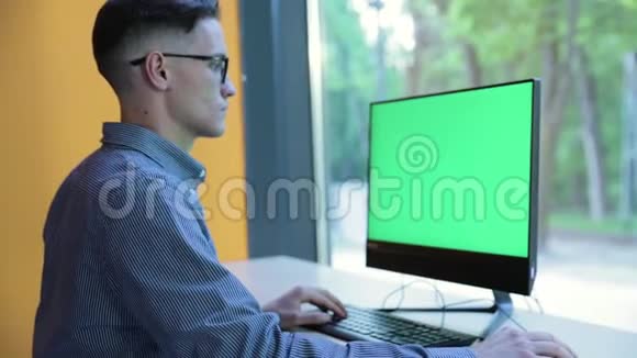 使用绿色屏幕显示器工作的年轻人视频的预览图