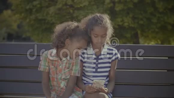 可爱的小女孩在手机上玩网络游戏视频的预览图