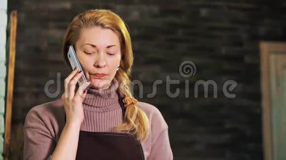 柜台后面的女花匠在打电话看着平板电脑视频的预览图