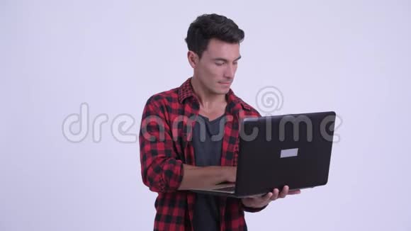 快乐的西班牙裔时髦男人在使用笔记本电脑时思考视频的预览图