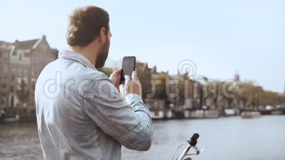 4K欧洲游客在桥上拍照智能手机摄影有自行车的成人休闲旅行者视频的预览图