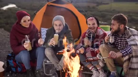 一家由四个高加索青年朋友组成的公司在山上野餐他们在聊天笑着视频的预览图