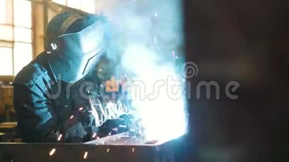 建筑工厂一名工人在头盔中使用焊机明亮的蓝色消防照明视频的预览图