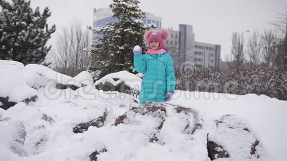 一个小女孩在冬天的公园玩雪球唱歌欢乐的打击视频的预览图