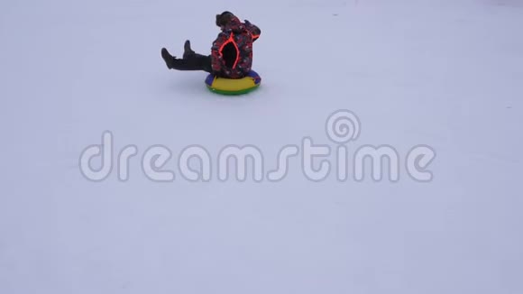 人在雪碟上滑下雪山笑了冬天雪橇上的圣诞节假期视频的预览图