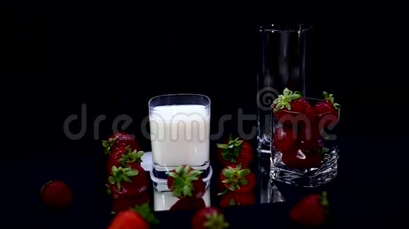 一颗草莓在牛奶黑背景下缓慢下落视频的预览图