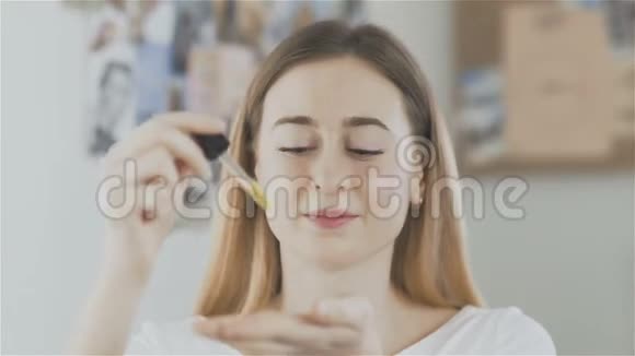 一个女人在脸上涂了一层油然后看着镜头视频的预览图