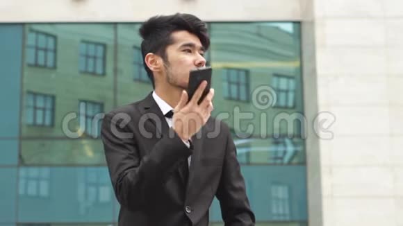 一位西装革履的亚洲人打电话视频的预览图