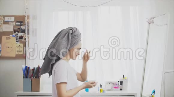 美丽的女人在毛巾上放保湿霜视频的预览图